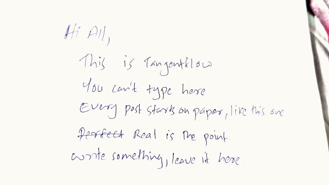 A piece of white paper with handwritten text in blue ink.