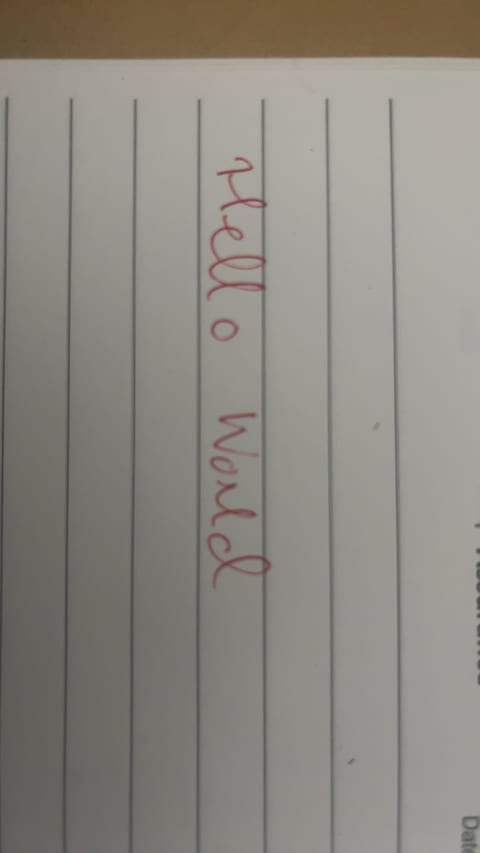 A piece of white lined paper with 'hello world' written in red ink.